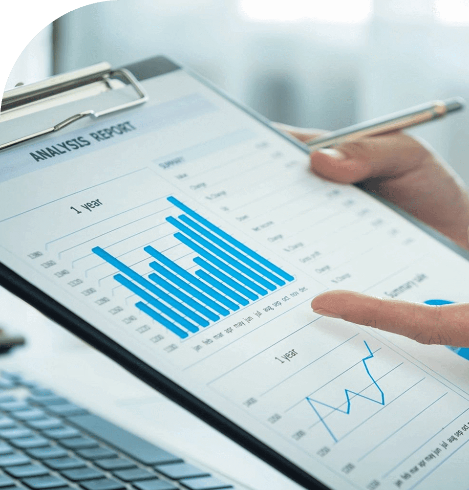 Person analyzing financial bar and line charts on a clipboard.