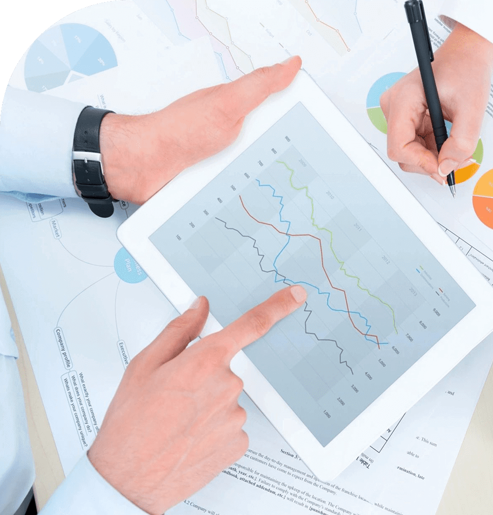 Two people analyzing data trends on a tablet with charts and graphs.