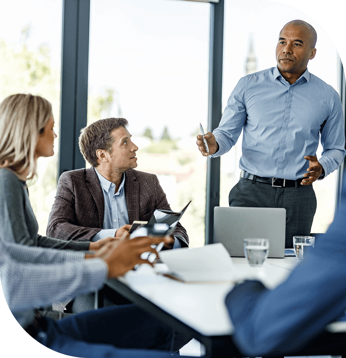 Businessman presenting ideas to colleagues in a meeting.