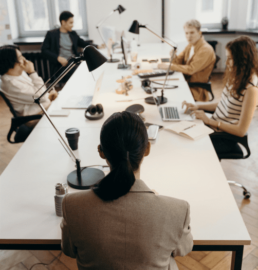 A team collaborates around a table in a modern office space.